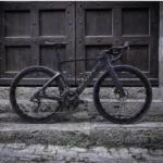 Vélo Scott Foil noir devant une porte en bois avec roues carbone 50mm forme de Wave