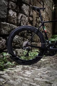 Roue 68mm arriere Legend Wheels noir devant un mur en pierre sur un vélo Colnago C68